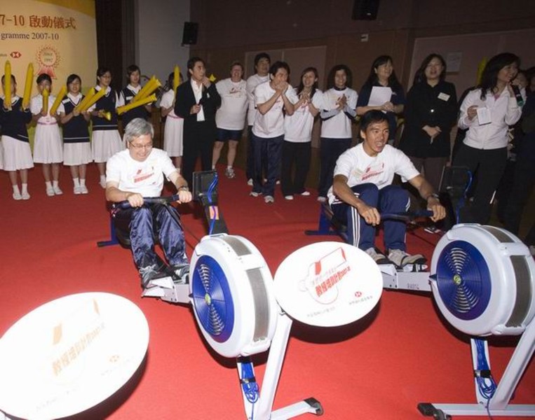 <p>Dr Eric Li (left) and rower Law Hiu-fung compete at the friendly indoor-rowing match.</p>
