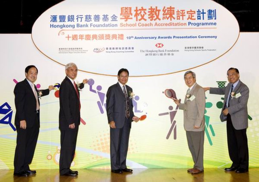 <p>Officiating guests Prof Frank Fu (2<sup>nd</sup> from left), Chairman of the Hong Kong Coaching Committee and Kenneth Ng (middle), Head of Legal and Compliance, The Hongkong and Shanghai Banking Corporation Limited, together with Dr Eric Li (2<sup>nd</sup> from right), Chairman of the HKSI, Tony Lai (1<sup>st</sup> from left), Chief Curriculum Development Officer (PE) of Education Bureau and Silas Chiang (1<sup>st</sup> from right), Secretary-General of Hong Kong Schools Sports Federation place the sports gears to the figures on the backdrop together in the kick-off ceremony, to highlight the pivotal role of school coaches and PE teachers in fostering school sports development and as a gesture to encourage continuous commitment.</p>
