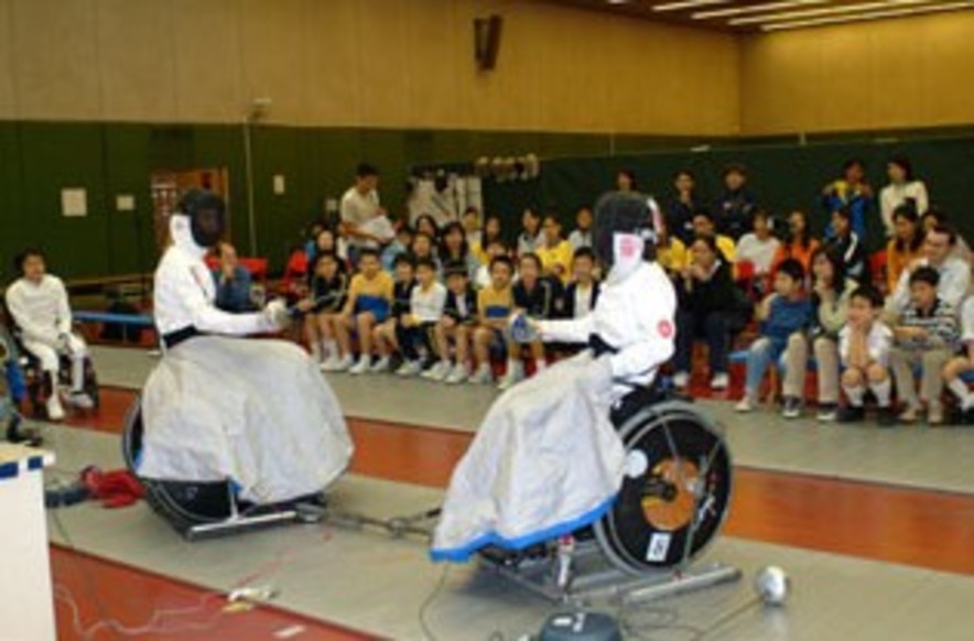 <p>海晓月与雅典伤残人士奥运会轮椅剑撃金牌得余翠怡（左）作剑击交流。</p>
