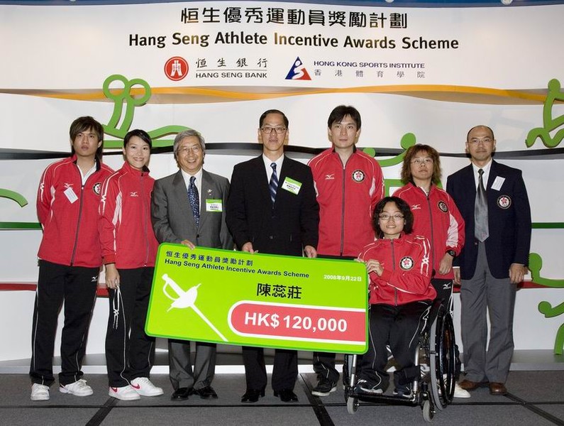 <p>体院主席李家祥博士（左三）及民政事务局局长曾德成(左四)颁发奖金予轮椅剑击队，表扬他们的杰出表现。</p>
