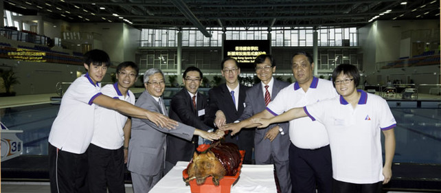 At the HKSI New Facilities Soft Opening, Mr Tsang Tak-sing GBS JP (4th from right), Secretary for Home Affairs; Mr Carlson Tong JP (4th from left) and Dr Eric Li GBS OBE JP (3rd from left), present and former Chairman of the HKSI respectively; Mr Pang Chung SBS (3rd from right), Hon Secretary General of the Sports Federation & Olympic Committee of Hong Kong, China; (from right) swimmer Sze Hang-yu and HKSI Head Swimming Coach Chan Yiu-hoi; (from left) rower Liao Shun-yin and HKSI Assistant Rowing Coach Alex Lo, participate in the roast pig cutting ceremony to celebrate the soft opening of the 52m International Standard Indoor Swimming Pool.
