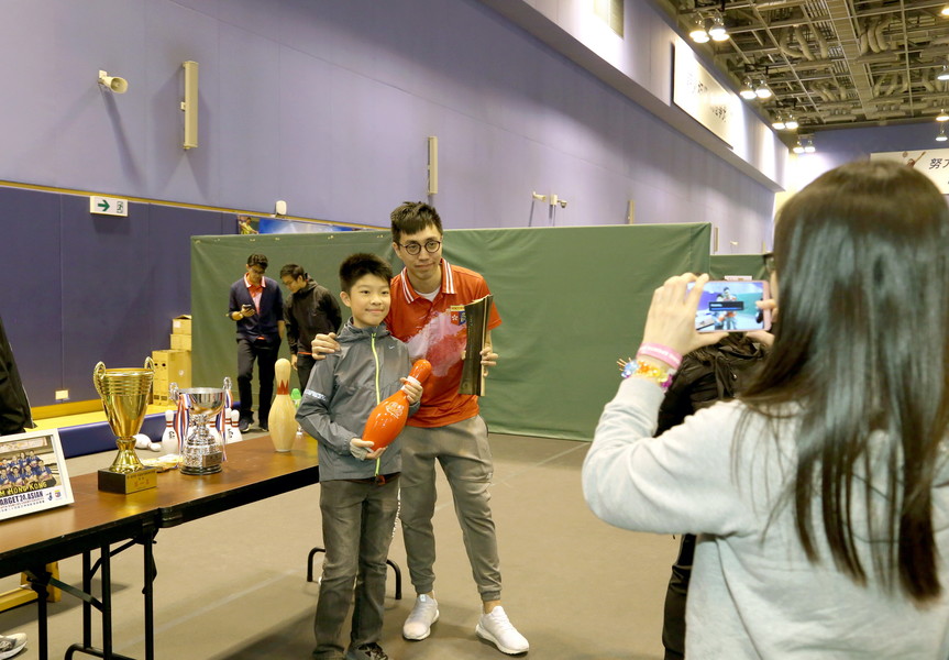 参加者在保龄球摊位试玩，并与亚洲保龄球锦标赛冠军麦卓贤合照，打成一片。