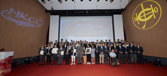 2018 年共有 113 位教练夺得「精英教练奖」。香港体育学院董事谢家德博士（前排，左七）恭贺他们在 2018 年带领运动员/运动队伍於国际赛事中夺得骄人成绩。